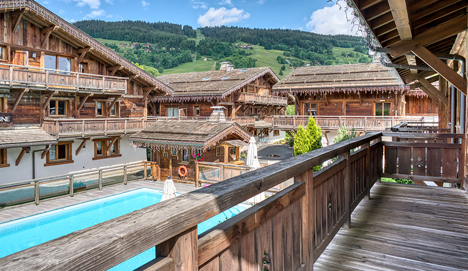 Les Loges Blanches hôtel 4* Megève vue terrasse sur la piscine extérieure au sein du hameau
